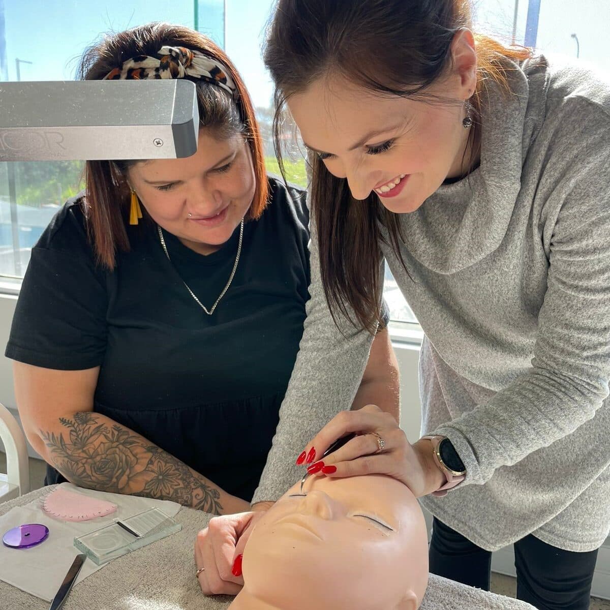 Stella Academy educator supporting a lash student